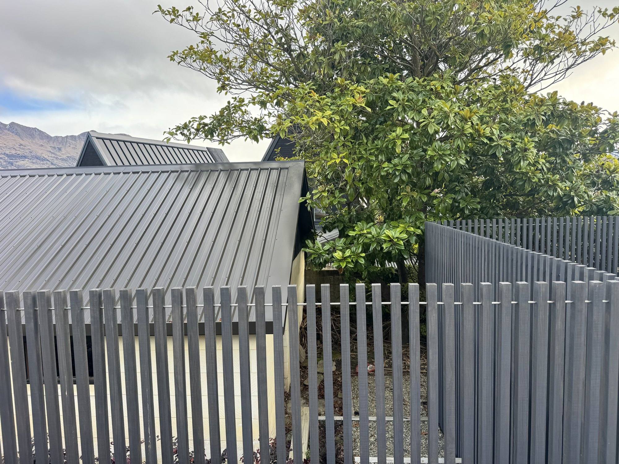 Grey exterior timber fence beside a Wānaka home